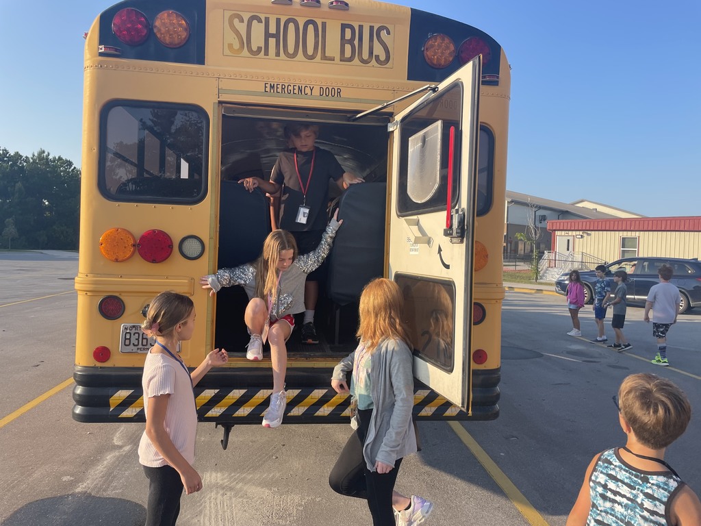 students climbing out of the back of a bus