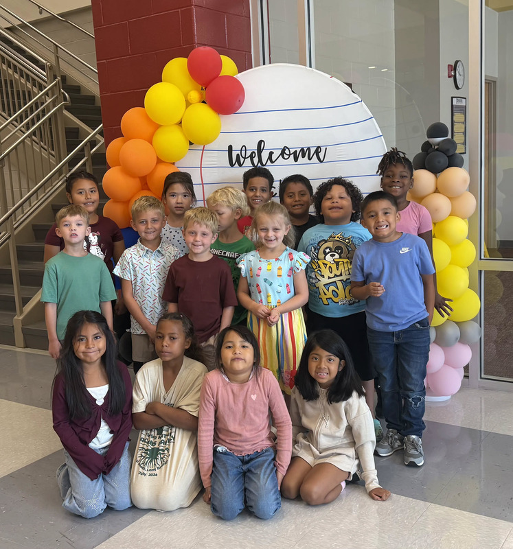 Students next to welcome back sign