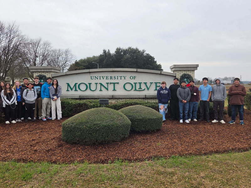 students in front of mount olive sign