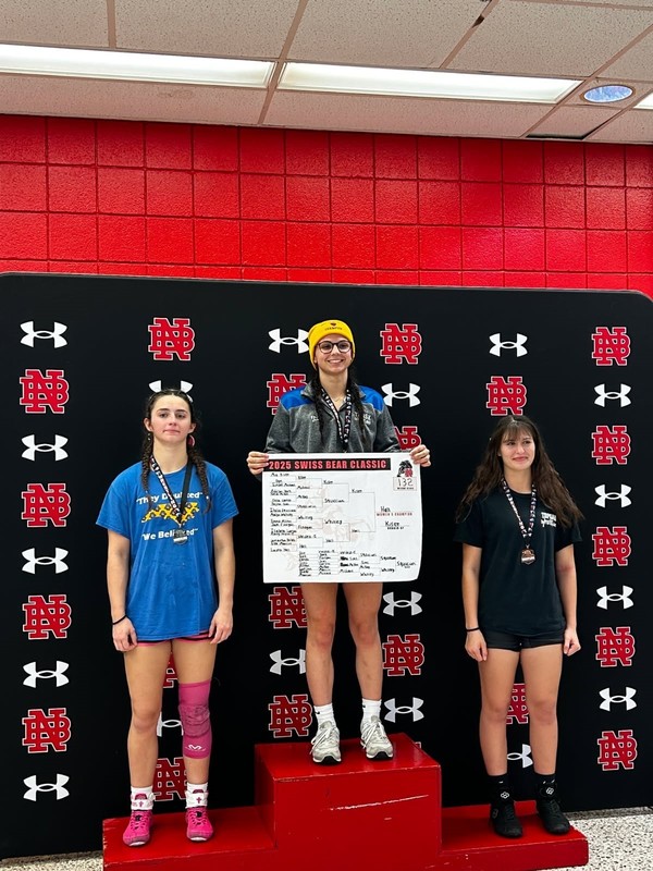 students on podium at wrestling competition