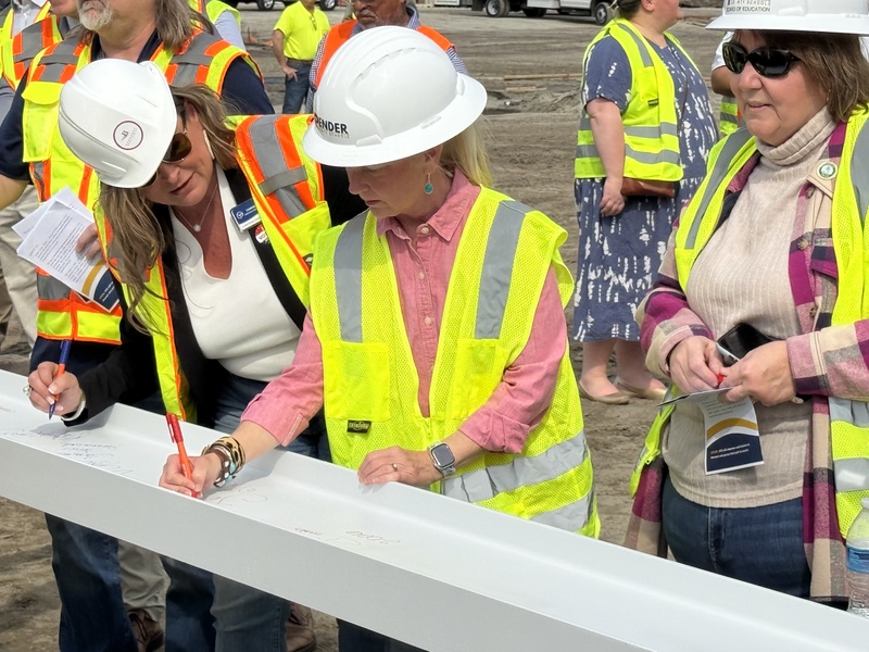 Jennifer Hansen, Vice Chair signing the beam
