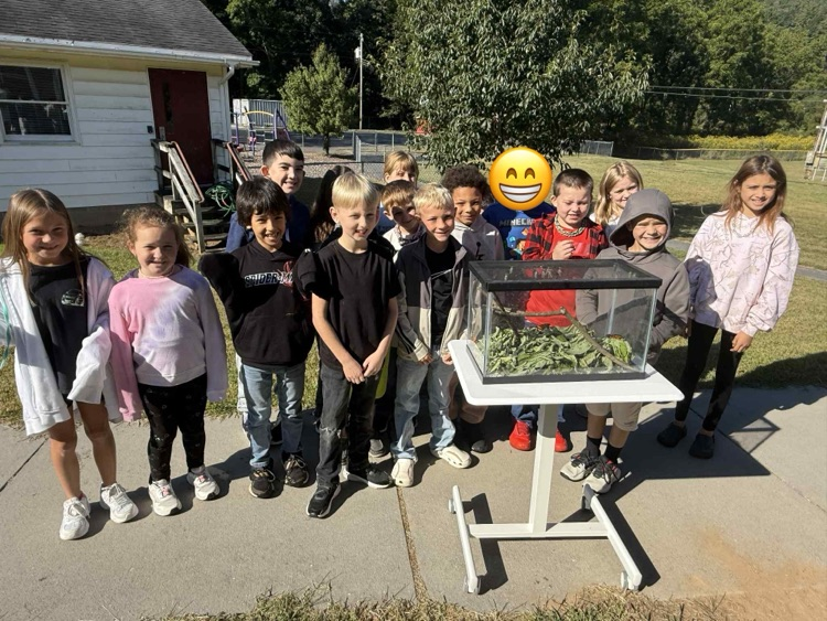 students posing for picture with butterflies