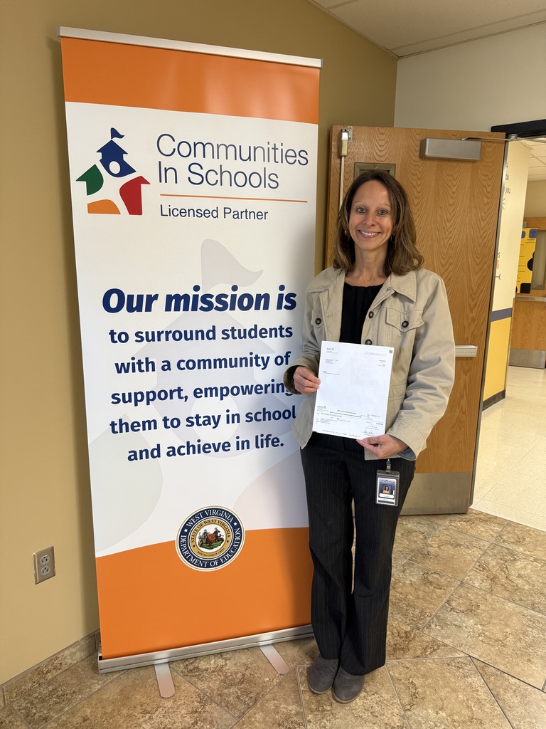 Picture of Community in Schools Coordinator, Wendy Kisamore with a donation check 
