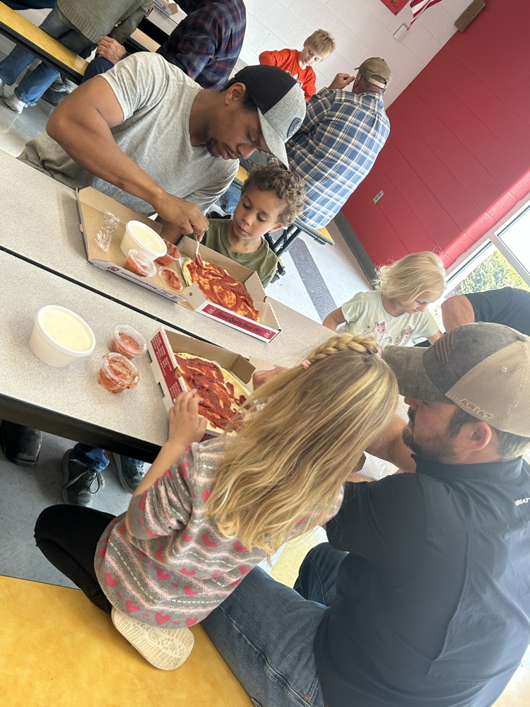students and their guests making pizza