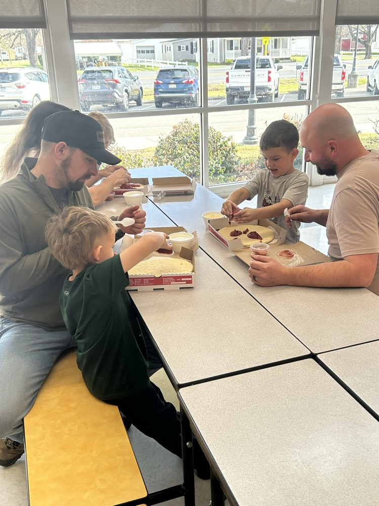 students and their guest making pizza