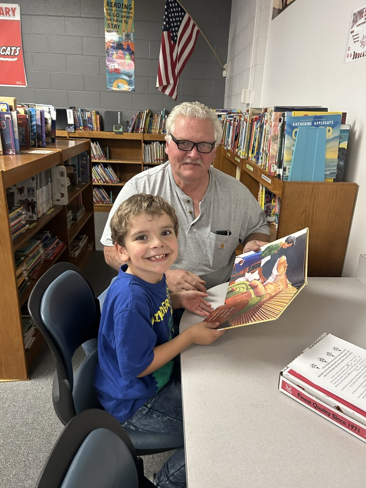 student and their guest reading a book