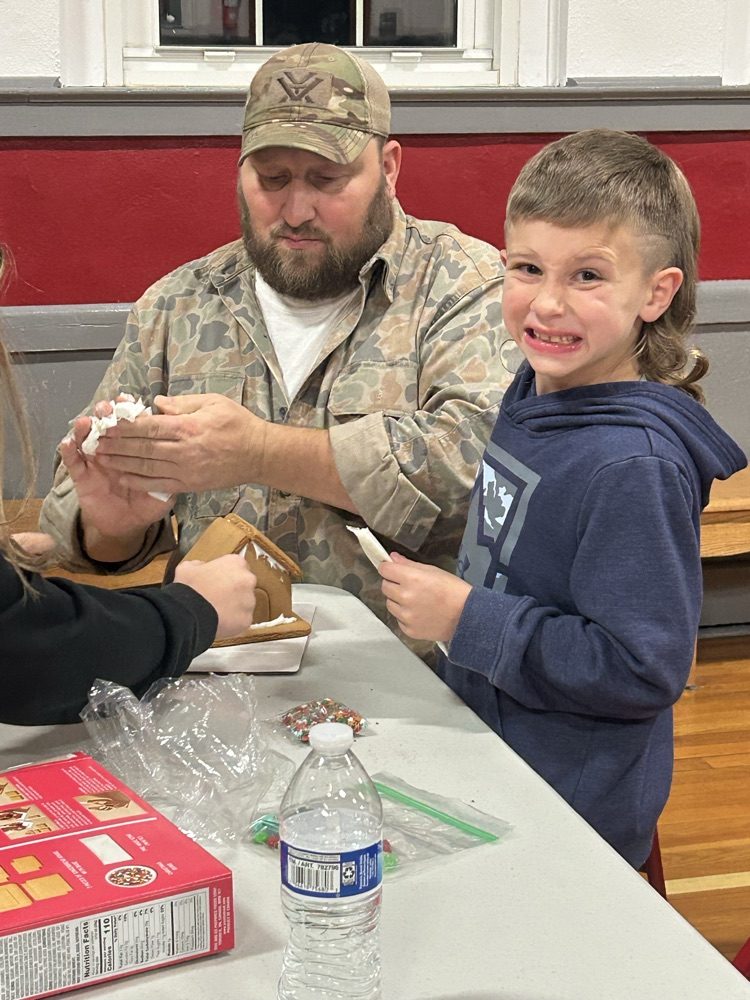 Families working together to build a gingerbread house 