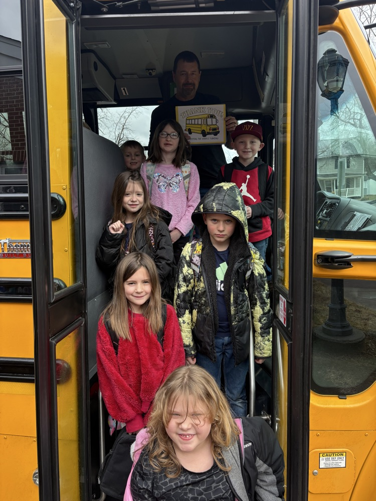Students standing with their bus driver and their thank you cards! 