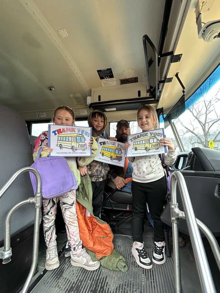Students standing with their bus driver and their thank you cards! 