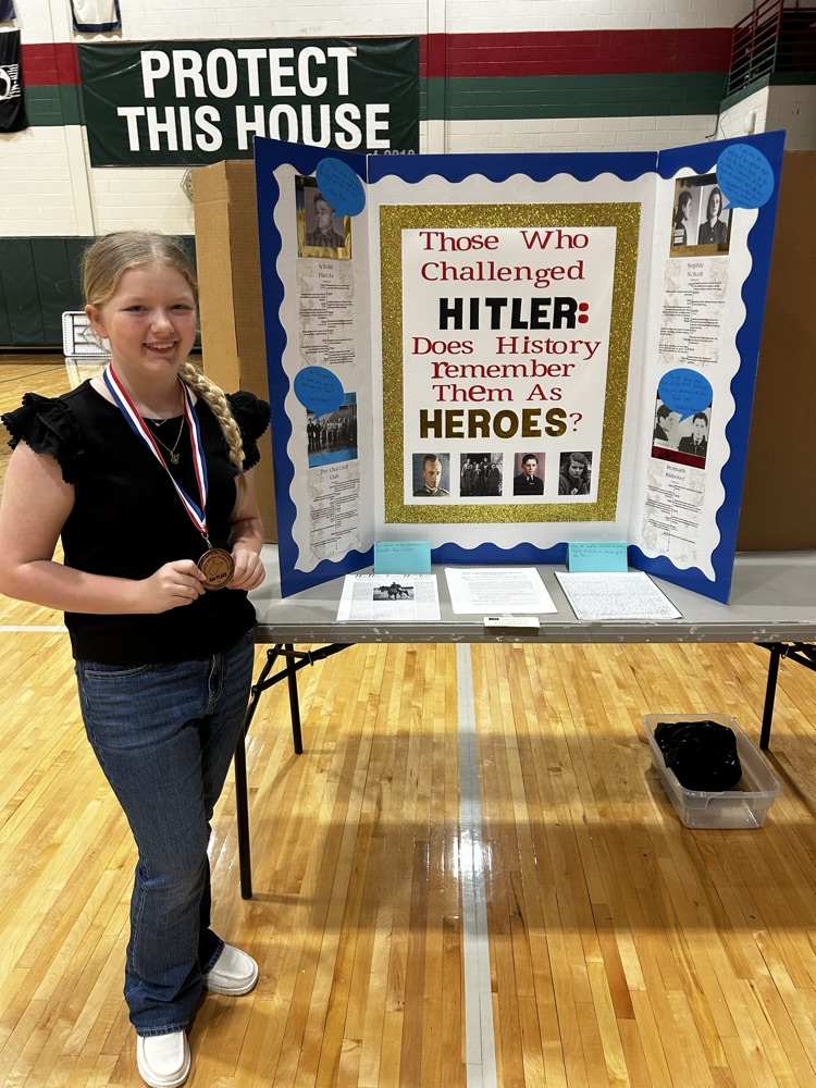 Student with her social studies fair project about Those who challenged Hitler.