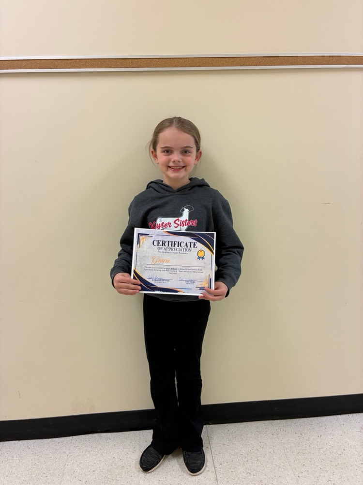 A girl holding a certificate for selling the most Bundt cakes