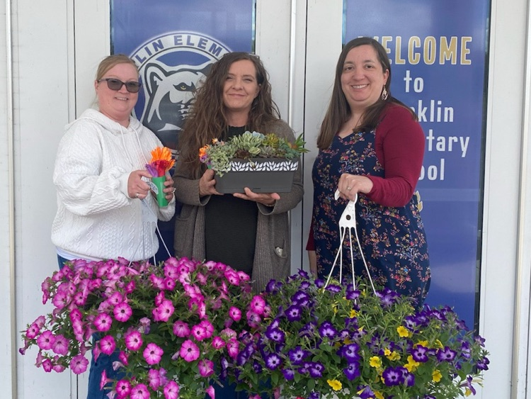 3 members of Admin from FES holding flower baskets
