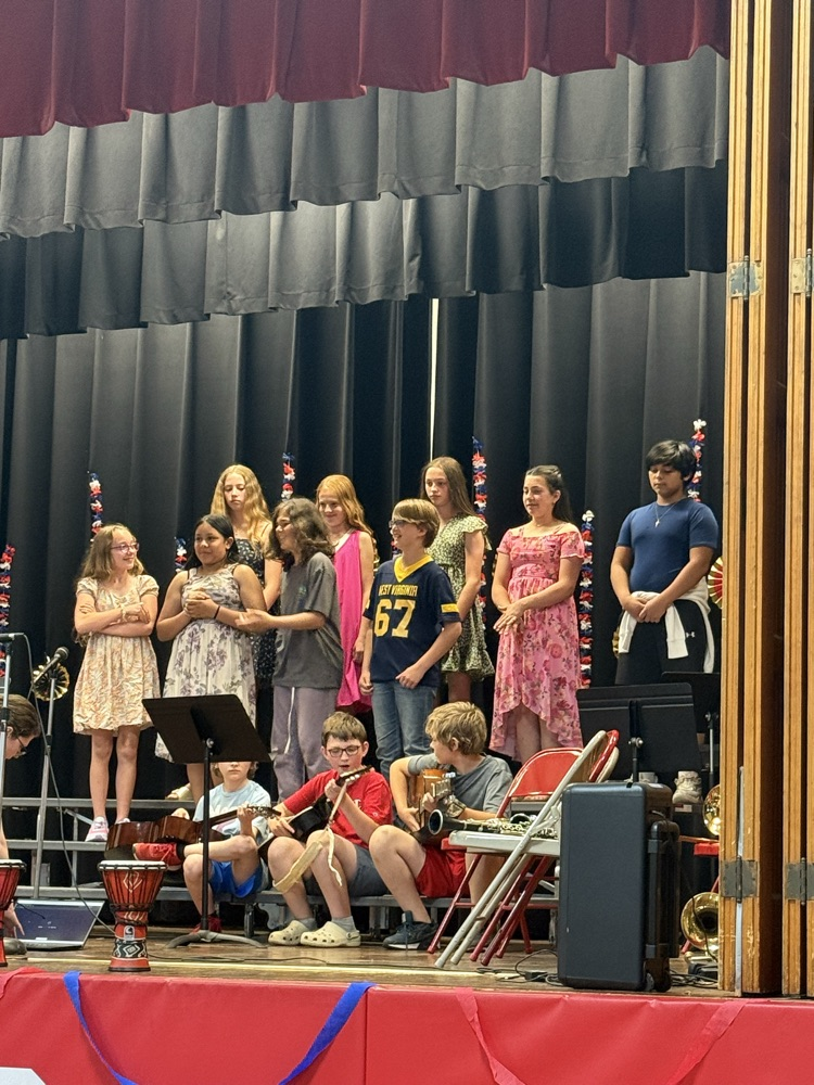 5th and 6th graders singing and playing guitars. 