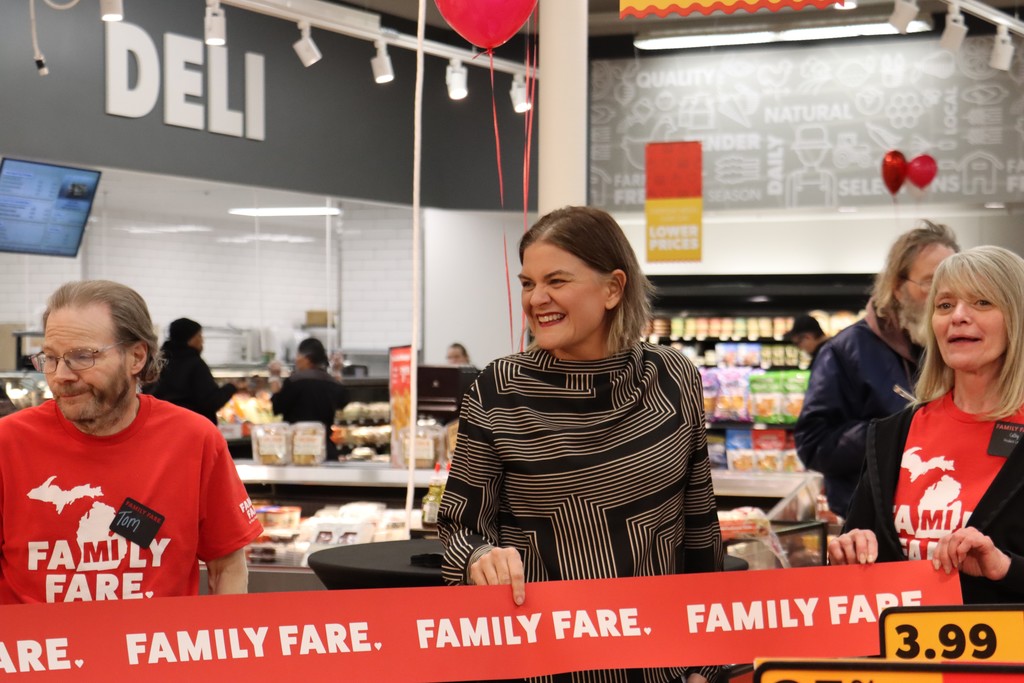Superintendent Stephanie Lemmer Standing behind Red FAmily Fare ribbon smiling