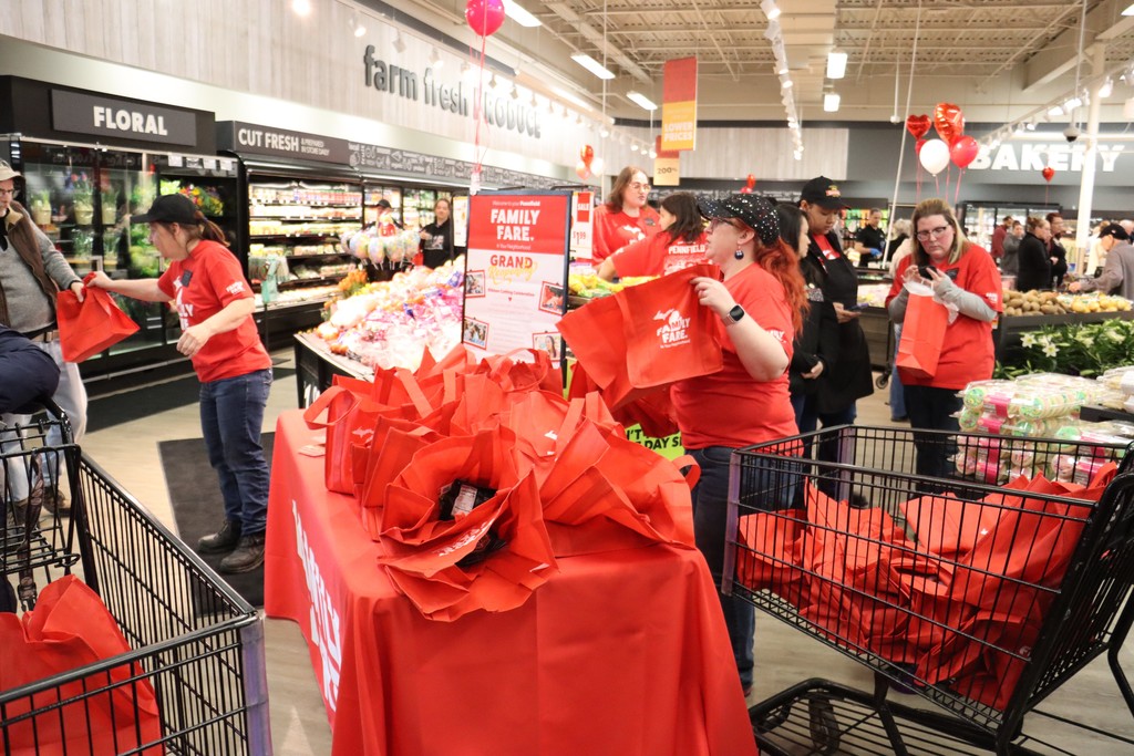 Red Family Fare free rescuable bags sitting on table in middle of grocery store.