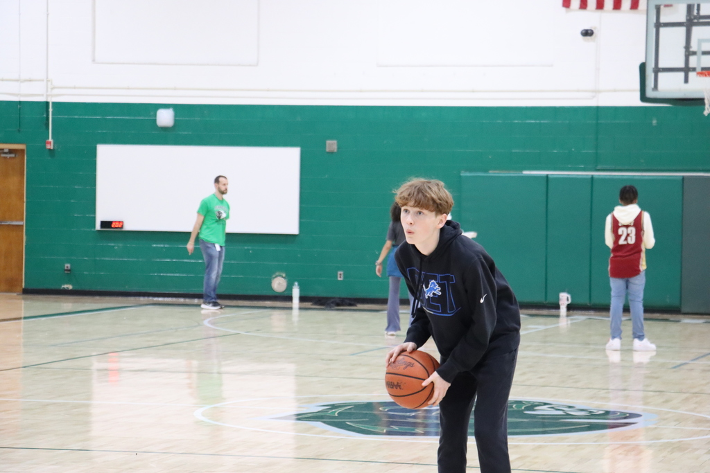 Student in the gym with a basketball in his hand getting ready to dribble and shoot