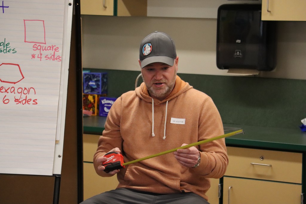 Construction worker showing off measuring tape