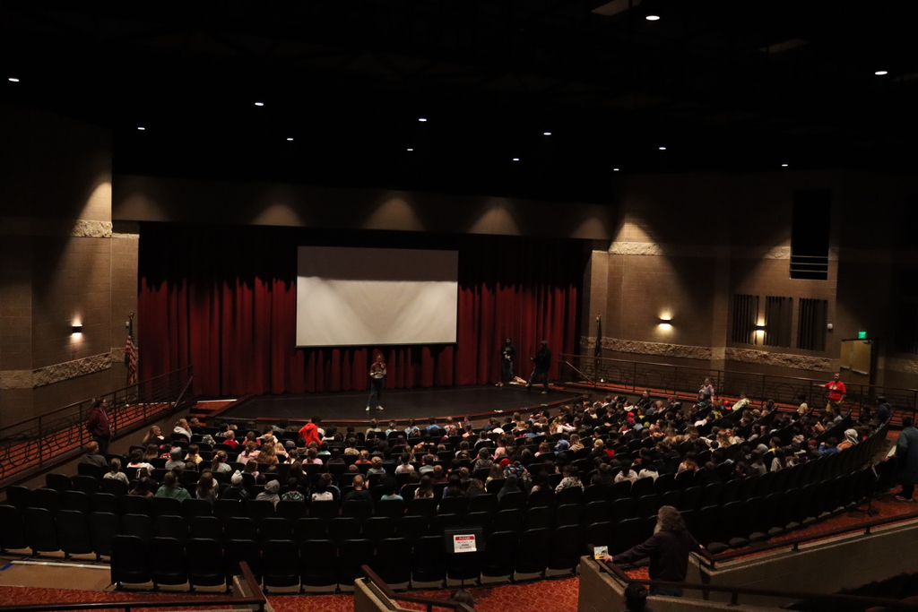 Dunlap Elementary Students sitting in auditorium facing stage listening to principal talking