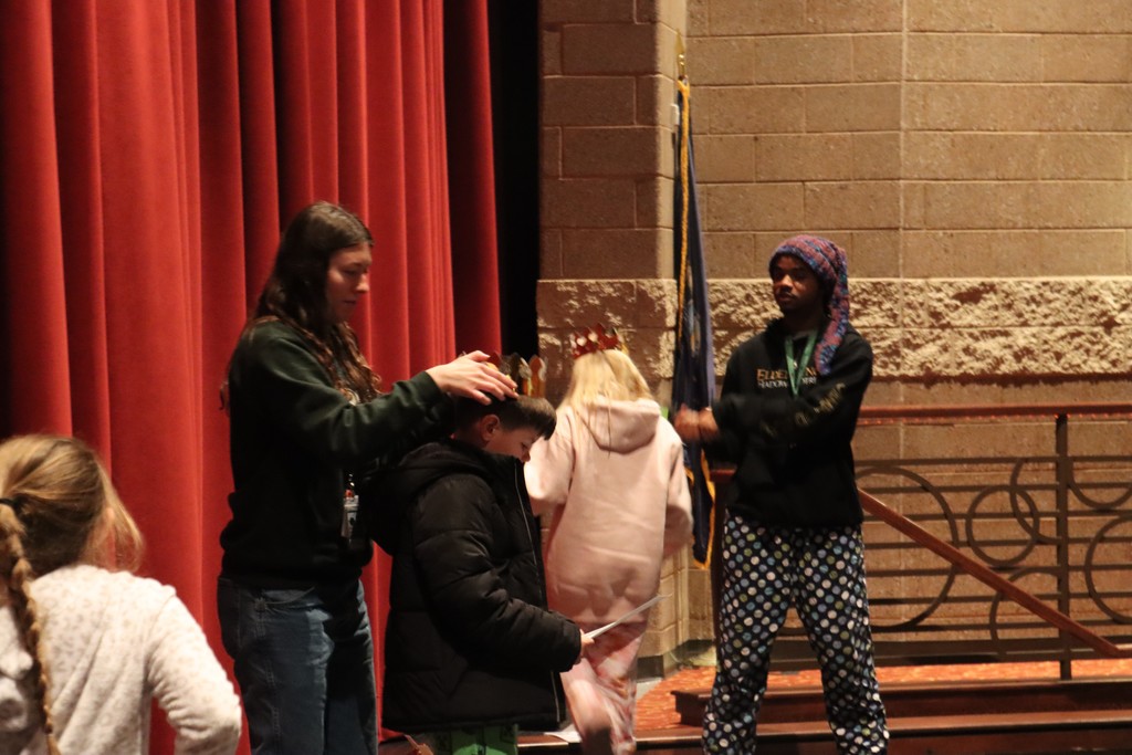Student being crowned on stage by teacher