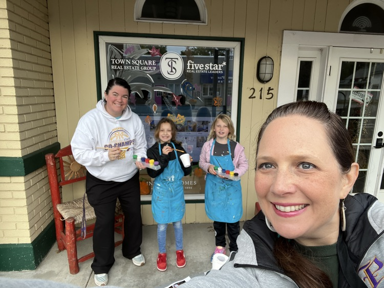 4th graders painting business windows