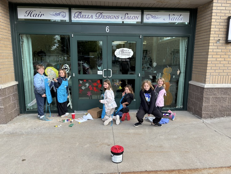 4th graders painting business windows