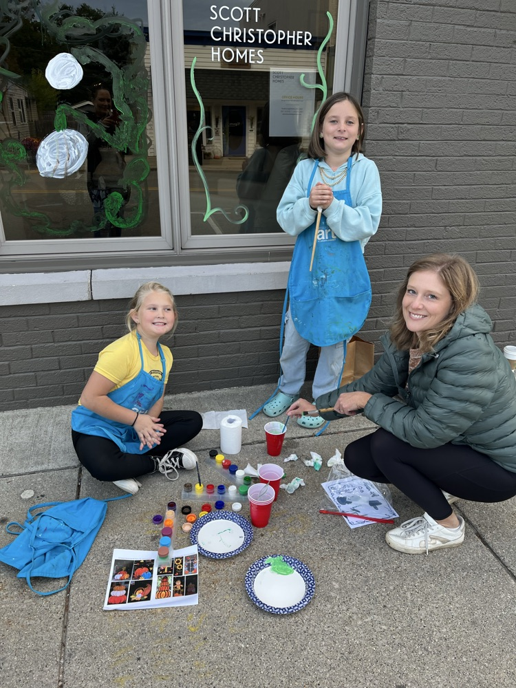4th graders painting business windows