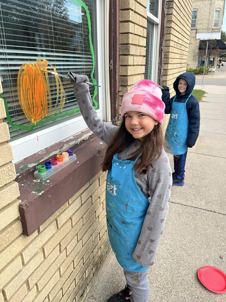 4th graders painting business windows
