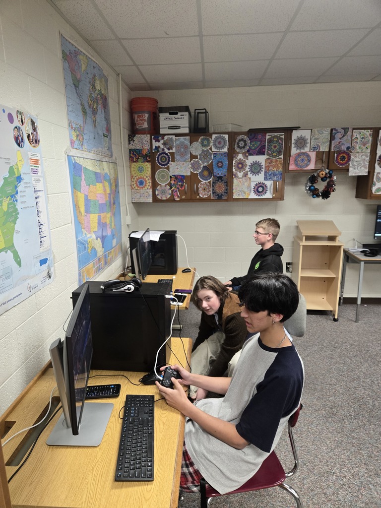 3 boys at computers playing Rocket League