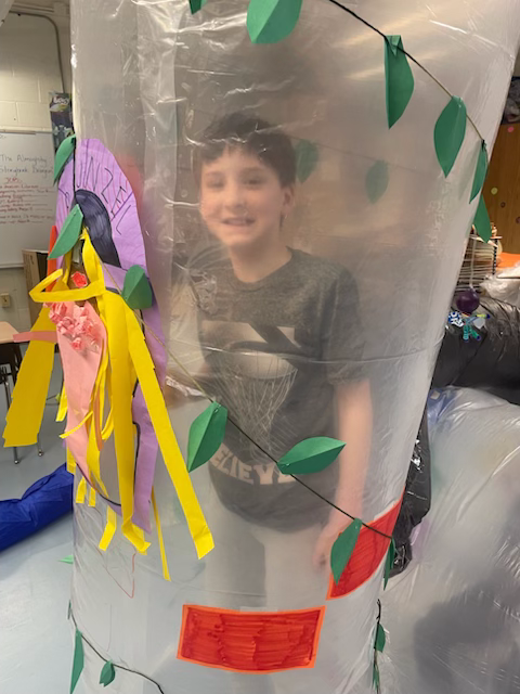 Student posing after crawling through an art installation