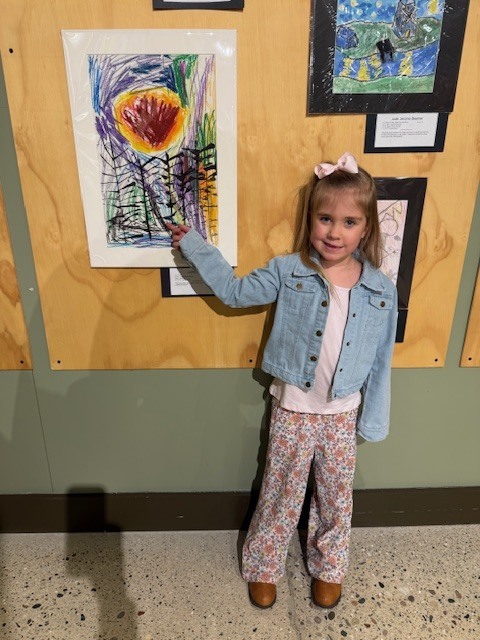 Student pointing to her sun artwork.