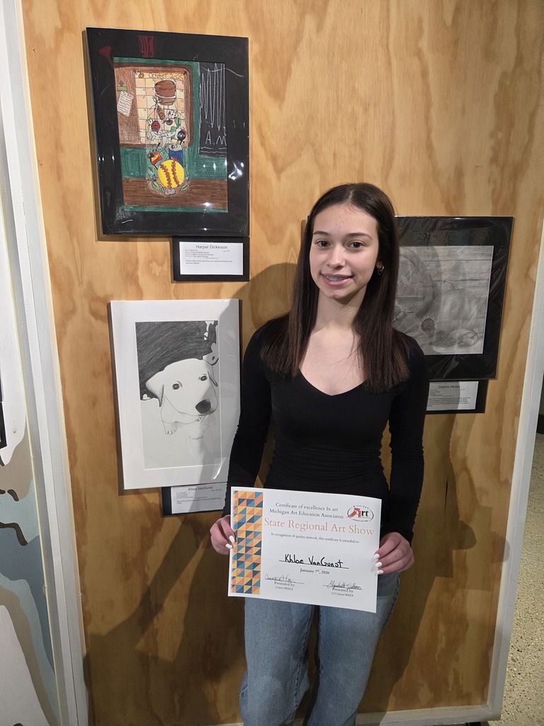 Student standing next to her dog drawing.