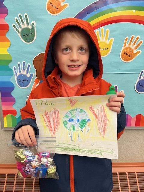 Kindergarten grade winner holding art, Henry VerVelde
