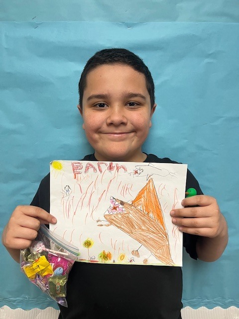 3rd grade winner holding art, Draco Santana