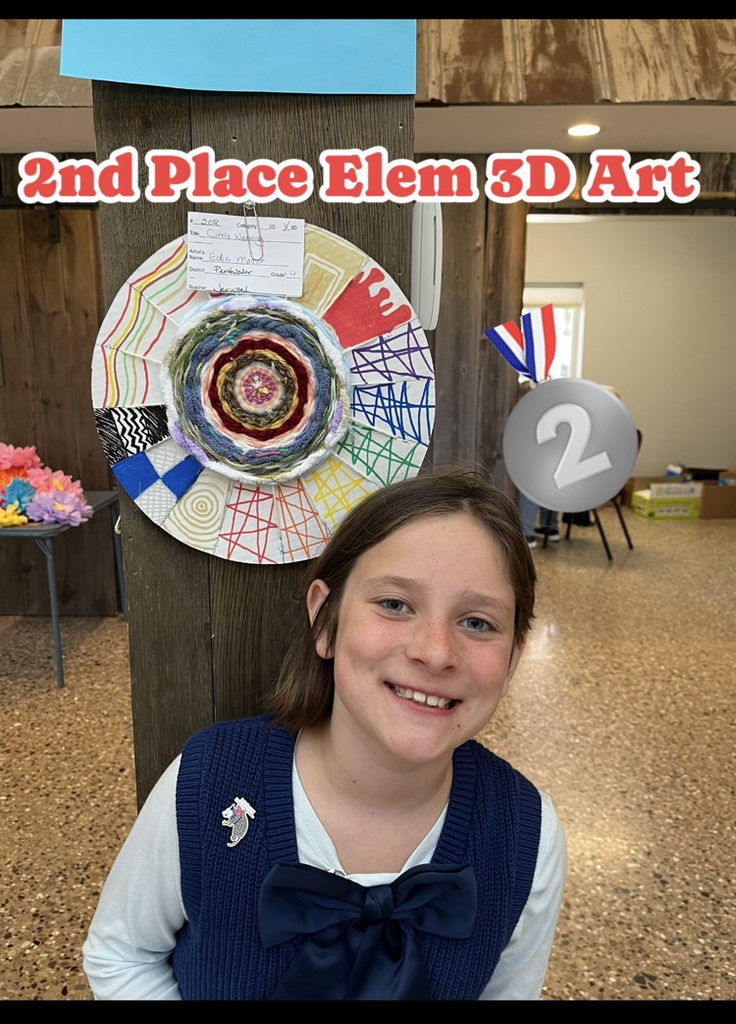 Edie stands in front of her circle weaving. 