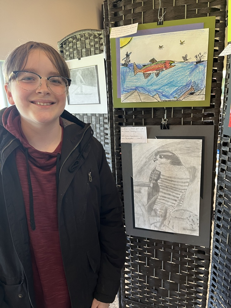 Niko stands in-front of his bird drawing.  