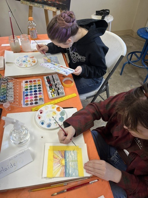 Two students are watercolor painting.