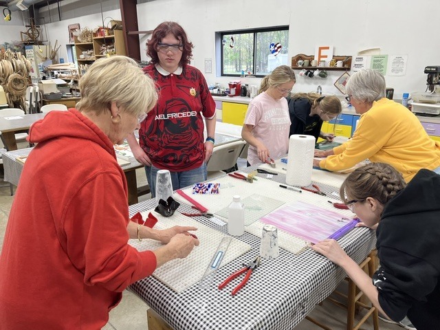 Sue is demonstrating how to score and cut glass.