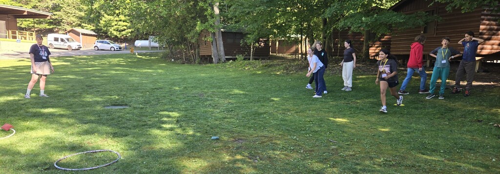 Middle schoolers throwing a bean bag at a hula hoop