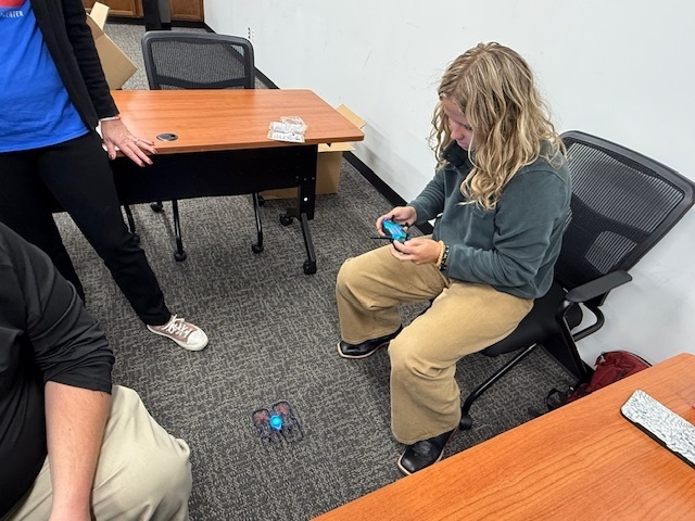 Teacher learning how to fly a drone.