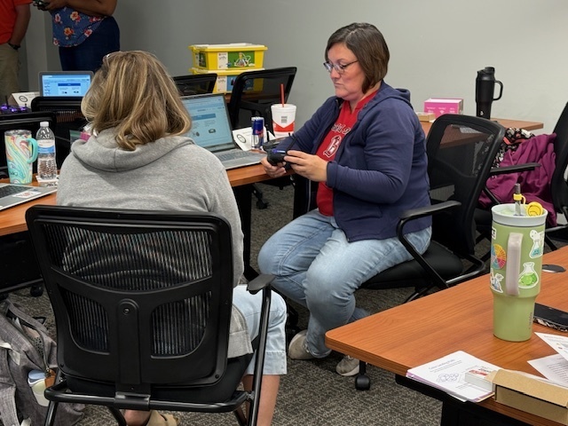 Teacher learning how to use the drone controller.