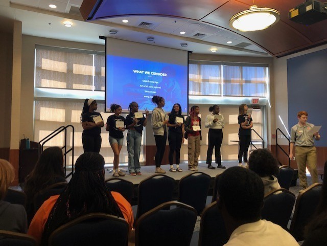 Students participate in an activity to learn how college admissions works.
