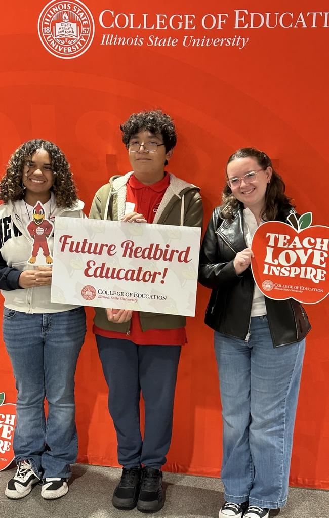 3 students posing with future teacher signs 