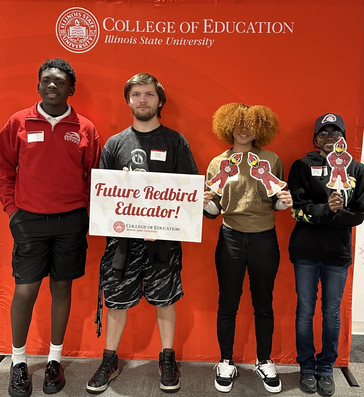 4 students posing with future teacher signs 