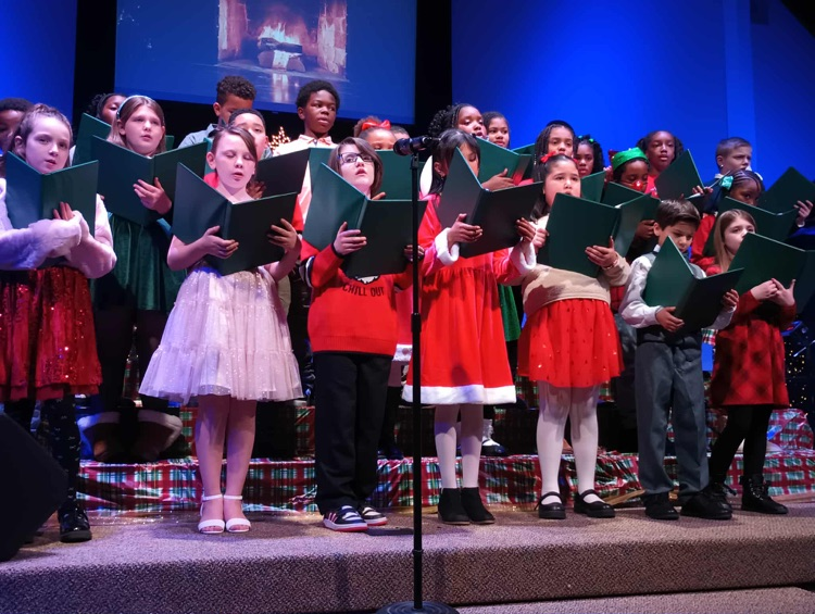 The choir is learning how to conduct themselves professionally in a performance setting. They did such a good job with their music folders! 