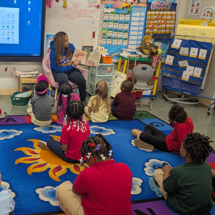 woman reading aloud to kindergarten class