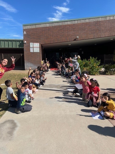 Students greeting guests outside the office