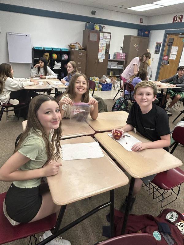 students pose with mummy making supplies