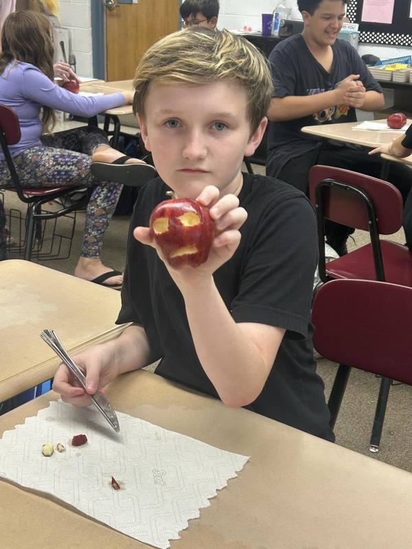 Student poses with apple mummy 