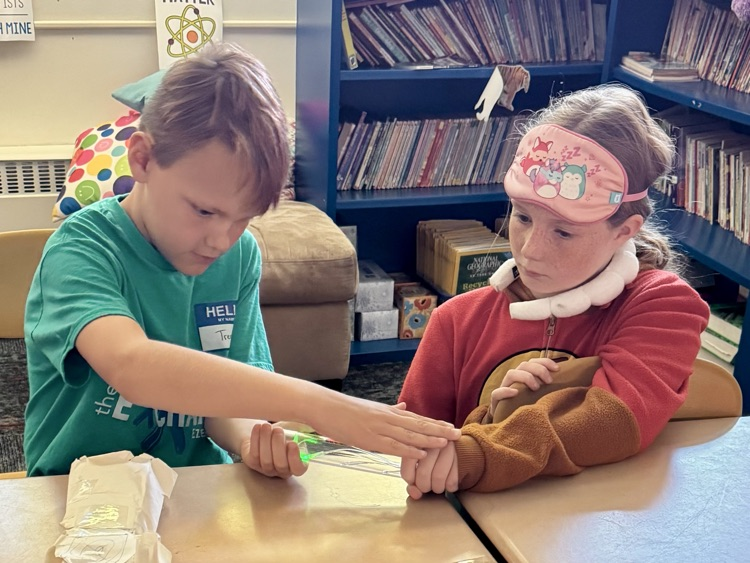 Fourth graders are testing out energy sticks as an end of the unit celebration. They are figuring out different ways to close a circuit.