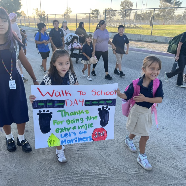 students walking to school with a sign